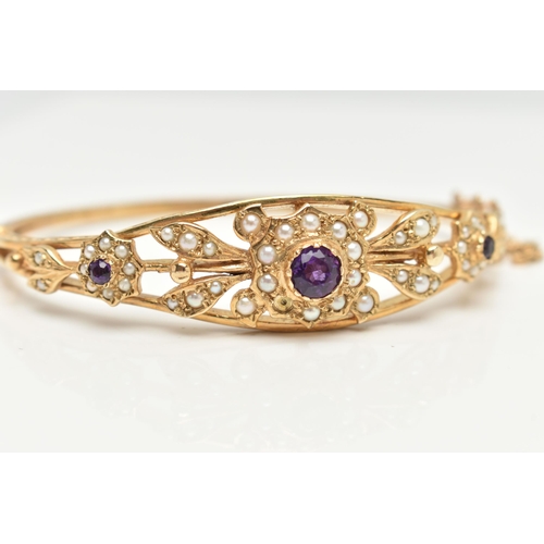 75 - A 9CT GOLD AMETHYST AND SEED PEARL HINGED BANGLE, floral pattern bangle set with three circular cut ... 