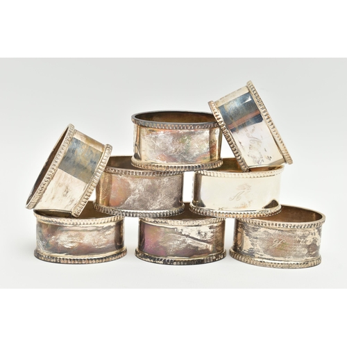 153 - A SET OF EIGHT ELIZABETH II OVAL SILVER NAPKIN RINGS, fluted rims, all engraved with initial 'A', ma... 