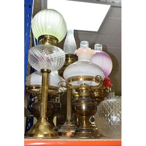 442 - A GROUP OF EIGHT VICTORIAN OIL LAMPS, mainly brass and metal bases, assorted coloured glass shades (... 