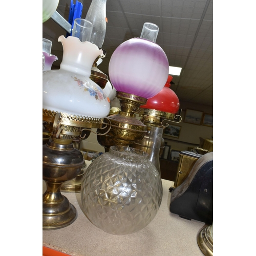 442 - A GROUP OF EIGHT VICTORIAN OIL LAMPS, mainly brass and metal bases, assorted coloured glass shades (... 