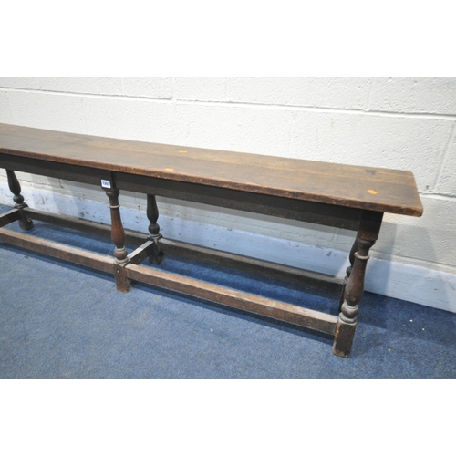 1207 - A LONG EARLY 20TH CENTURY OAK BENCH, on six turned uprights, united by stretchers, length 168cm x de... 