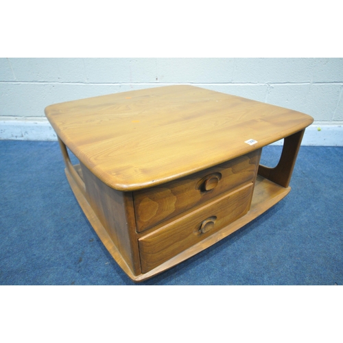 1299 - AN ERCOL ELM MODEL 735 PANDORA'S BOX ROLLING COFFEE TABLE, with an arrangement of drawer and storage... 