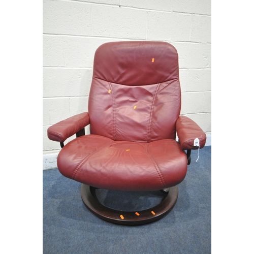 1312 - AN EKORNES STRESSLESS RED LEATHER RECLINING SWIVEL ARMCHAIR, and a footstool (condition report: chai... 