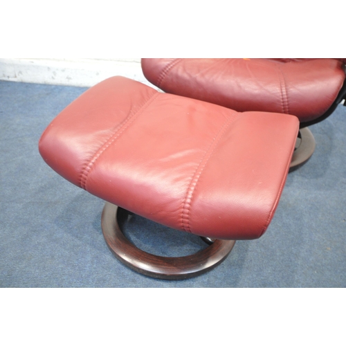 1312 - AN EKORNES STRESSLESS RED LEATHER RECLINING SWIVEL ARMCHAIR, and a footstool (condition report: chai... 