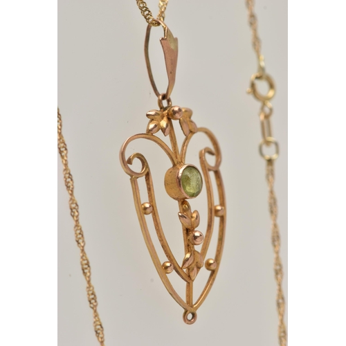 24 - AN EDWARDIAN PENDANT AND CHAIN, open work floral pendant, set with a circular cut peridot, missing d... 