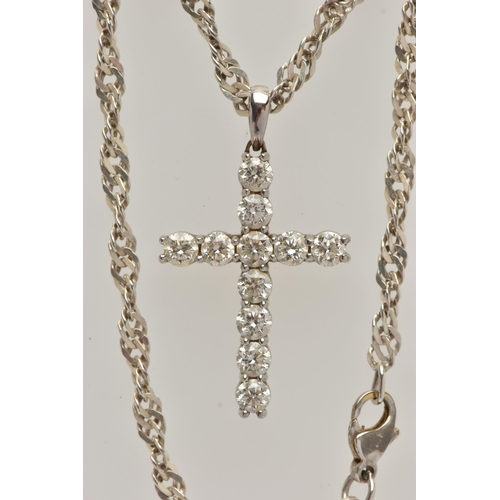 4 - A WHITE METAL DIAMOND CROSS PENDANT AND A CHAIN, the cross pendant claw set with eleven round brilli... 