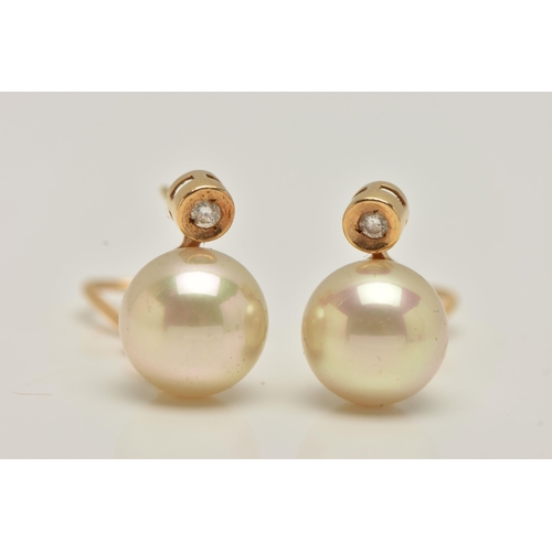 46 - A PAIR OF IMITATION PEARL AND DIAMOND EARRINGS, each designed as a brilliant cut diamond above an im... 