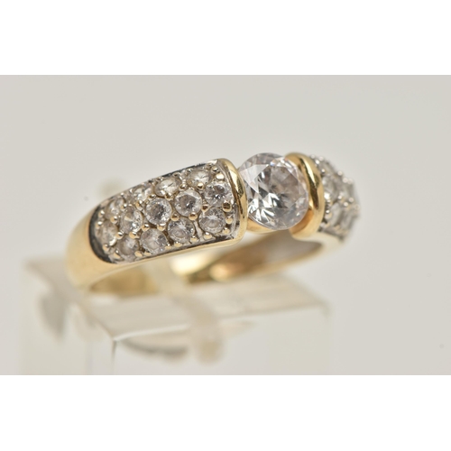 47 - A 14CT GOLD CUBIC ZIRCONIA RING, designed as a central circular colourless cubic zirconia flanked by... 