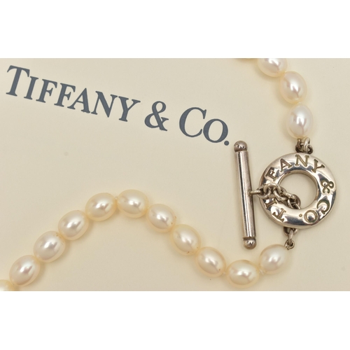 63 - A 'TIFFANY & CO' FRESH WATER PEARL TOGGLE NECKLACE, a string of forty four oval cultured fresh water... 