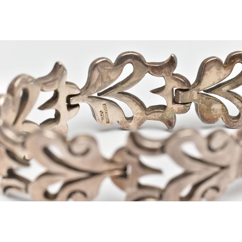 107 - A HEAVY WHITE METAL BRACELET, abstract foliage design, fitted with an integrated folding box clasp, ... 