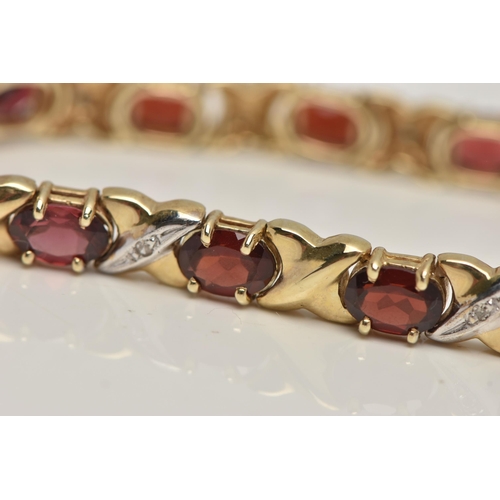 17 - A 9CT GOLD AND GARNET BRACELET, twelve oval cut garnets, prong set in yellow metal, interspaced betw... 