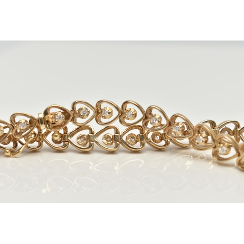 28 - A YELLOW METAL AND DIAMOND BRACELET,  heart link bracelet, each link set with a round brilliant cut ... 