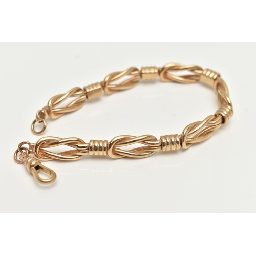 43 - A YELLOW METAL FANCY LINK BRACELET, comprised of seven lovers knots, fitted with a spring clasp, app... 