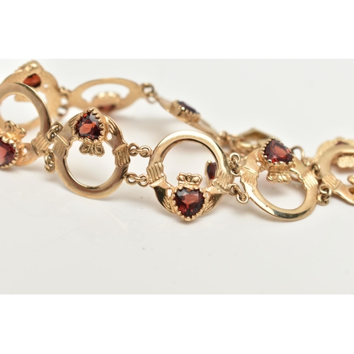 60 - A 9CT GOLD AND GARNET CLADDAGH BRACELET, nine circular claddagh links, each set with a heart cut gar... 