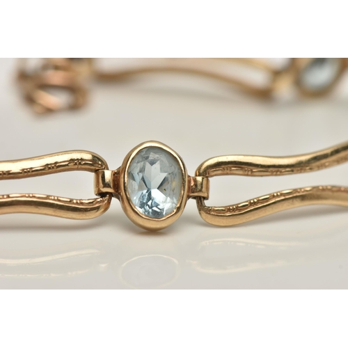 7 - AN AQUAMARINE BRACELET, five oval cut aquamarines bezel set in yellow metal interspaced between elon... 