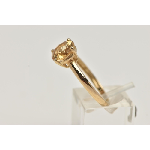 70 - A 9CT GOLD CITRINE RING, the circular cut Citrine within a four claw setting to the plain band, with... 