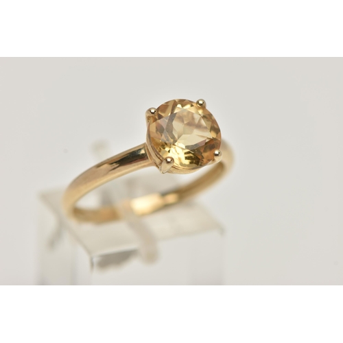 70 - A 9CT GOLD CITRINE RING, the circular cut Citrine within a four claw setting to the plain band, with... 