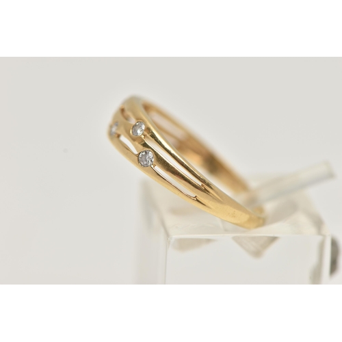 73 - AN 18CT GOLD DIAMOND DRESS RING, the tapered band with pierced detail, flush set with six brilliant ... 