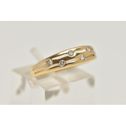 73 - AN 18CT GOLD DIAMOND DRESS RING, the tapered band with pierced detail, flush set with six brilliant ... 