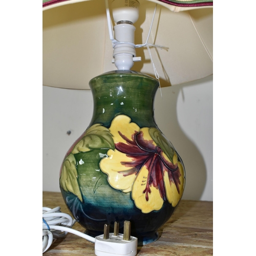 367 - A MOORCROFT POTTERY 'HIBISCUS' TABLE LAMP, decorated with red and yellow Hibiscus on a green ground,... 