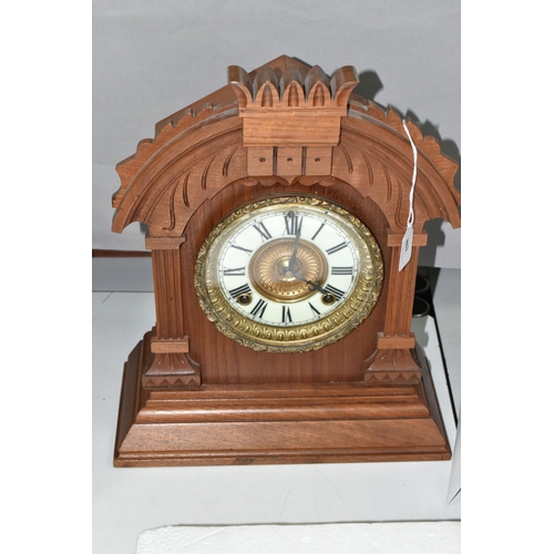 486 - A LATE 19TH CENTURY WALNUT CASED AMERICAN ANSONIA MANTEL CLOCK, the carved pediment above enamel dia... 