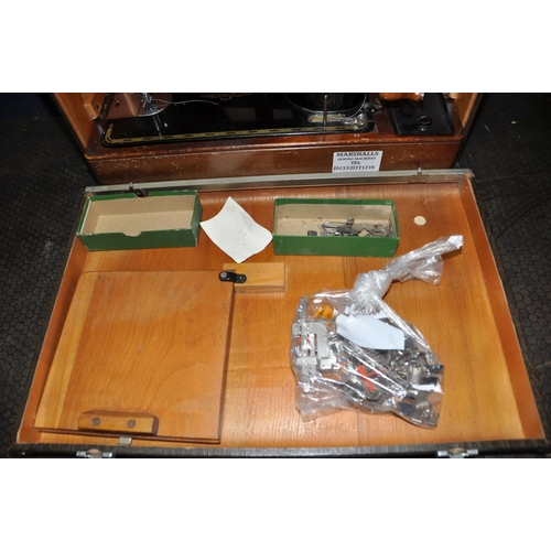 1093 - A VINTAGE CASED SINGER SEWING MACHINE in alligator skin style case with a quantity of accessories