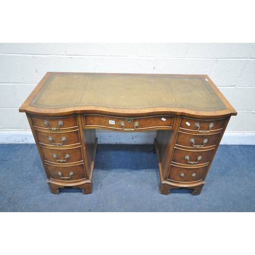 1216 - A BEVAN FUNNELL REPRODUCTION WALNUT SERPENTINE DESK, with a green leather writing surface, nine draw... 