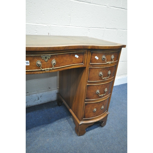 1216 - A BEVAN FUNNELL REPRODUCTION WALNUT SERPENTINE DESK, with a green leather writing surface, nine draw... 