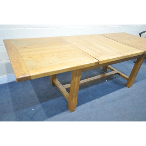 1227 - A LIGHT OAK EXTENDING DINING TABLE, with two drawers, on block legs, united by a H stretcher, extend... 