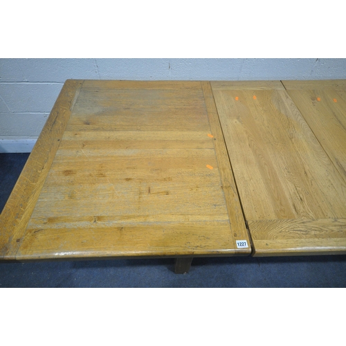 1227 - A LIGHT OAK EXTENDING DINING TABLE, with two drawers, on block legs, united by a H stretcher, extend... 