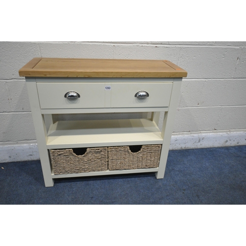 1243 - A MODERN PAINTED AND OAK SIDE TABLE, with a single long drawer, and two wicker baskets, width 82cm x... 