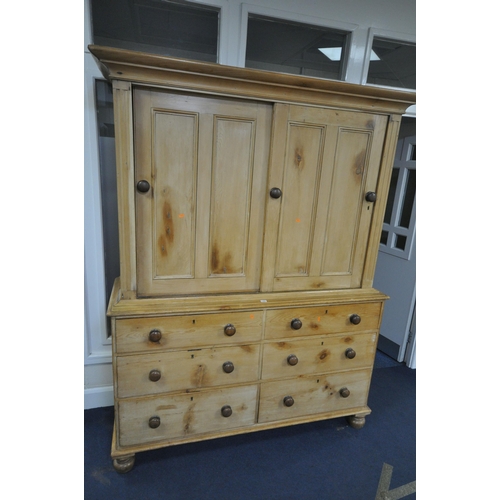 1262 - A 19TH CENTURY PINE HOUSEKEEPERS CUPBOARD, overhanging cornice, double panelled sliding doors enclos... 