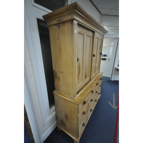 1262 - A 19TH CENTURY PINE HOUSEKEEPERS CUPBOARD, overhanging cornice, double panelled sliding doors enclos... 