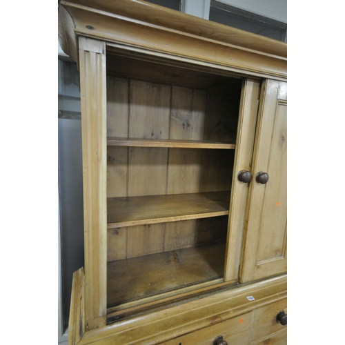 1262 - A 19TH CENTURY PINE HOUSEKEEPERS CUPBOARD, overhanging cornice, double panelled sliding doors enclos... 