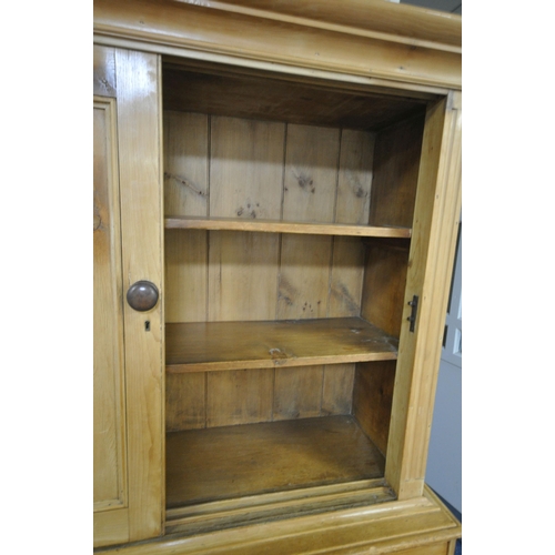 1262 - A 19TH CENTURY PINE HOUSEKEEPERS CUPBOARD, overhanging cornice, double panelled sliding doors enclos... 