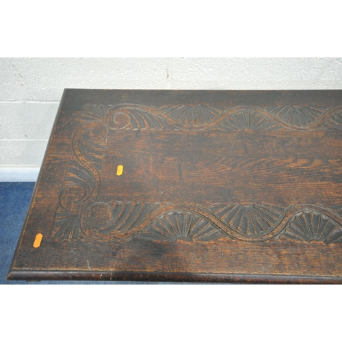 1304 - AN EARLY 20TH CENTURY CARVED OAK MONKS BENCH, with a pivoting top, and storage compartment, width 12... 