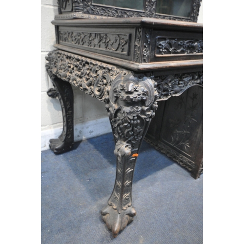 1353 - A 19TH CENTURY EBONISED ROSEWOOD CHINESE BOOKCASE ABOVE DESK, heavily carved throughout with dragons... 