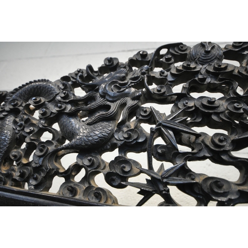 1353 - A 19TH CENTURY EBONISED ROSEWOOD CHINESE BOOKCASE ABOVE DESK, heavily carved throughout with dragons... 