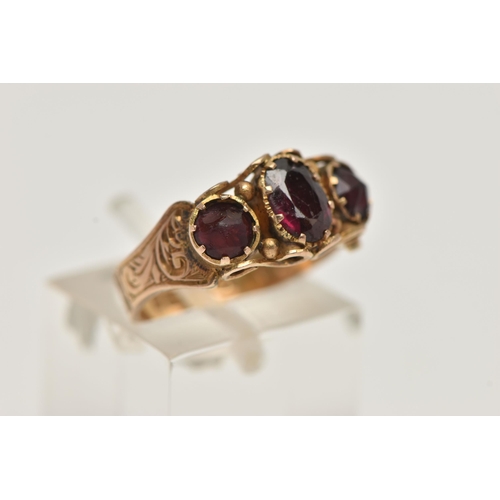 42 - A LATE 19TH CENTURY 9CT GOLD THREE STONE RING, central oval cut garnet set with two oval cut red pas... 