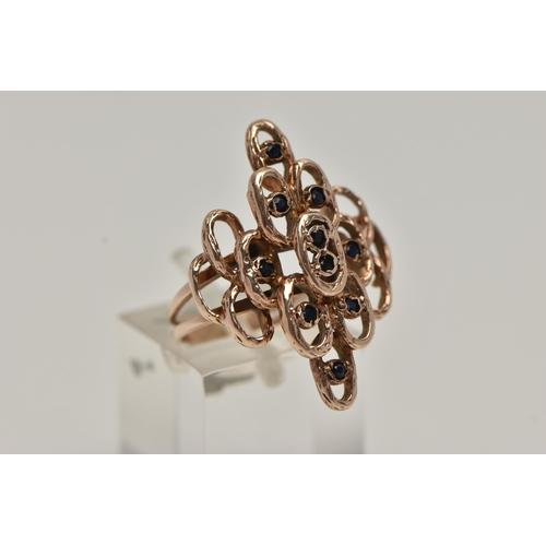 50 - A 9CT GOLD ABSTRACT RING, rose gold open work design, textured detail set with ten circular cut sapp... 