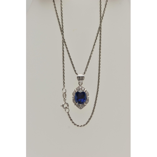 80 - A WHITE METAL PENDANT NECKLACE, the pendant set with an oval cut synthetic blue sapphire in a surrou... 