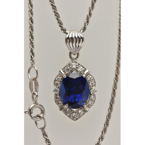 80 - A WHITE METAL PENDANT NECKLACE, the pendant set with an oval cut synthetic blue sapphire in a surrou... 