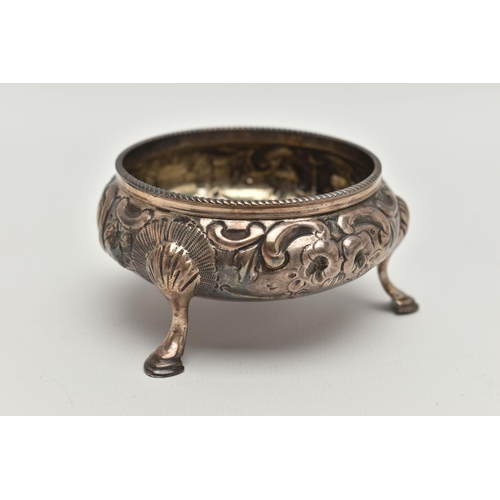 102 - A VICTORIAN SILVER CIRCULAR OPEN SALT, repoussé decorated with flowers and scrolls, on three cabriol... 