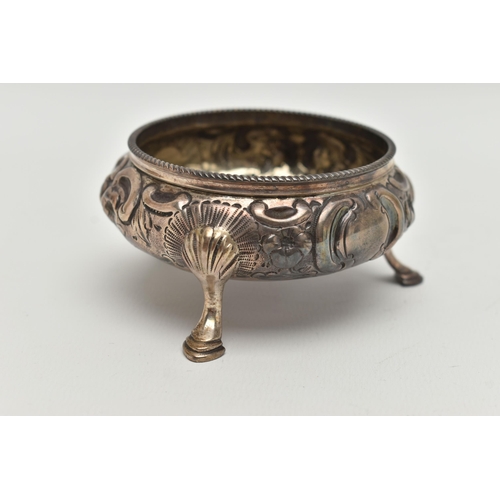 102 - A VICTORIAN SILVER CIRCULAR OPEN SALT, repoussé decorated with flowers and scrolls, on three cabriol... 