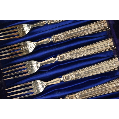 144 - A CASED SET OF SIX EDWARDIAN SILVER DESSERT KNIVES AND FORKS. the handles with a feathered pattern a... 