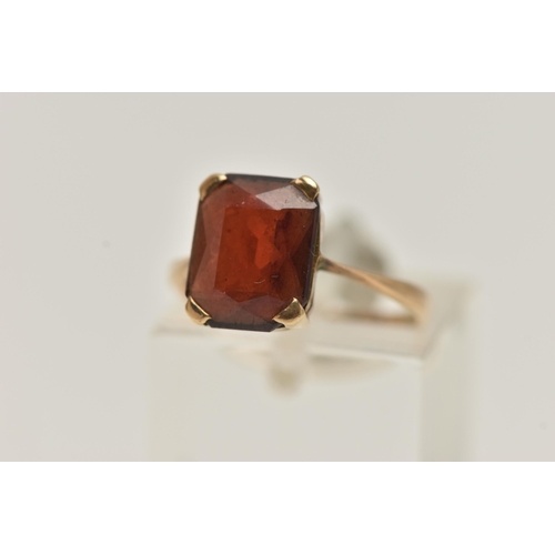 154 - A YELLOW METAL GEM SET RING, a rectangular cut garnet, prong set in yellow metal, stamped 9ct, ring ... 