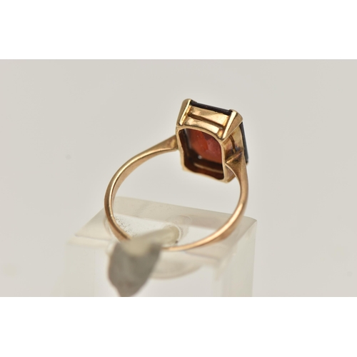 154 - A YELLOW METAL GEM SET RING, a rectangular cut garnet, prong set in yellow metal, stamped 9ct, ring ... 