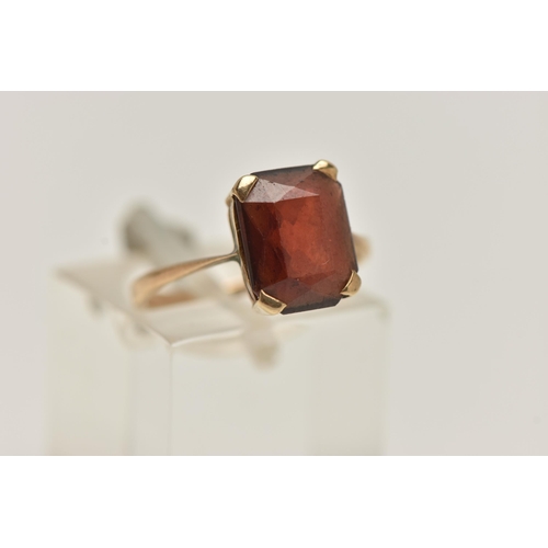 154 - A YELLOW METAL GEM SET RING, a rectangular cut garnet, prong set in yellow metal, stamped 9ct, ring ... 