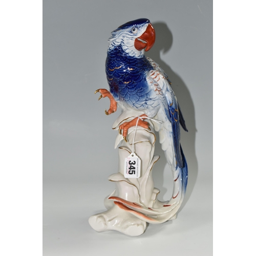 345 - A KARL ENS PORCELAIN 'MACAW' FIGURE, perched on top of a branch, blue and red gilt decoration, impre... 