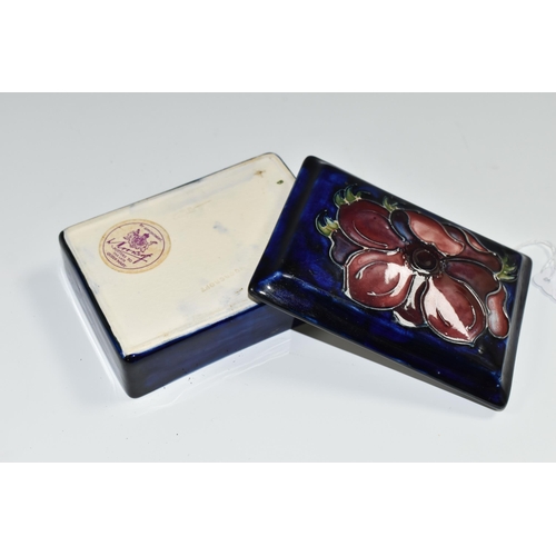 347 - A MOORCROFT POTTERY RECTANGULAR LIDDED TRINKET BOX, 'Anemone' pattern on a dark blue ground, paper Q... 